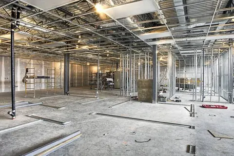 Office floor at fit-out stage with exposed services above the ceiling grid
