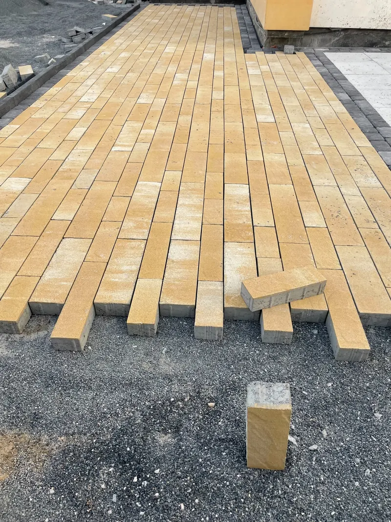 Yellow interlock pavers being laid, villa driveway