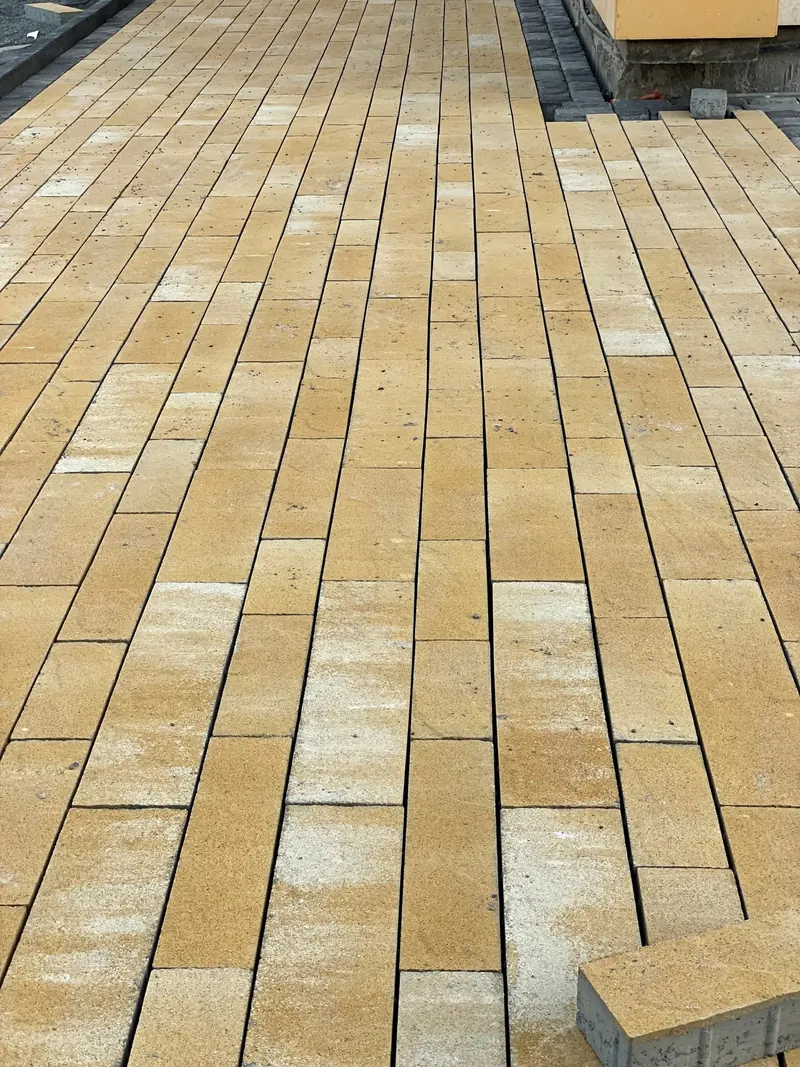 Yellow interlock pavers being laid, villa driveway — detail