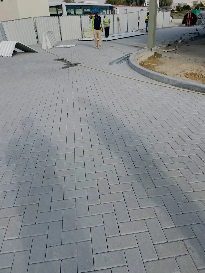 Freshly laid grey herringbone interlock across a warehouse yard
